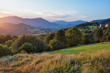 Naklejka na ściany i meble Fantastic sunset and bright grass in sunlight. Carpathian, Ukraine, Europe.