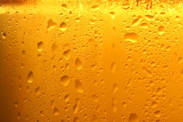 Glass of tasty cold beer with condensation drops as background, closeup