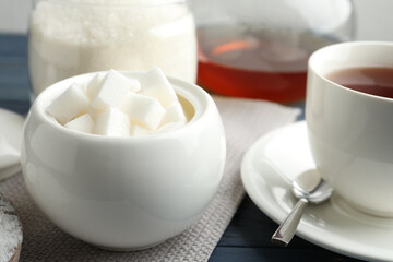 Refined sugar cubes in ceramic bowl on table