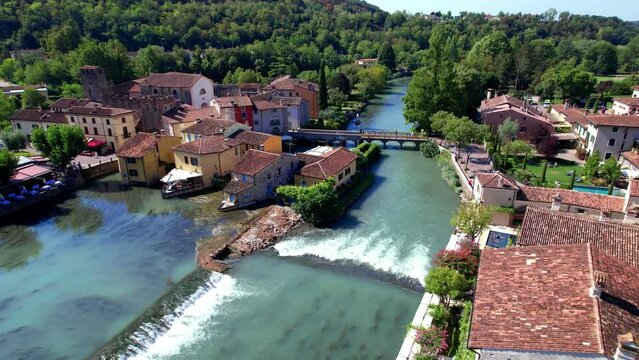 Borghetto sul Mincio aerial drone view. one of the most beautiful medieval villages of Italy. colorful houses located in the middle river and waterfalls. Verona province, near Garda Lake