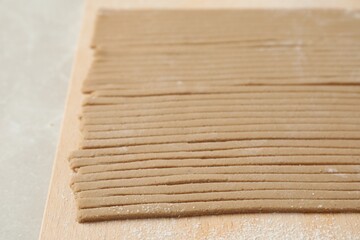 Uncooked soba (buckwheat noodles) on wooden table, closeup