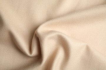 Fototapeta premium Beige soft cashmere fabric as background, closeup