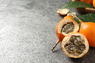Delicious ripe granadillas on grey table. Space for text