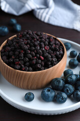 Fototapeta na wymiar Freeze dried and fresh blueberries on wooden table