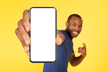 African American Man Showing Huge Cellphone Blank Screen, Yellow Background