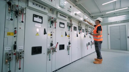 Electrical engineers inspect the electrical systems at the equipment control cabinet