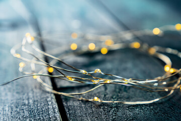 Fairy lights led garland coil, with bokeh, selective focus, on a dark blue rustic background....