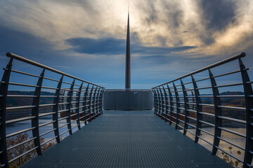 Fototapeta premium Skywalk am Aussichtspunkt Biggeblick mit Blick auf den Biggesee und die umliegenden Wälder bei Sonnenuntergang