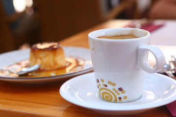 cup of coffee and pudding dessert closeup photo in open air Spanish cafe