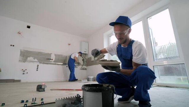 Installing ceramic floor tiles - measuring and cutting the pieces. Construction, renovation, repair apartment. Cuts tile. Tile cutting