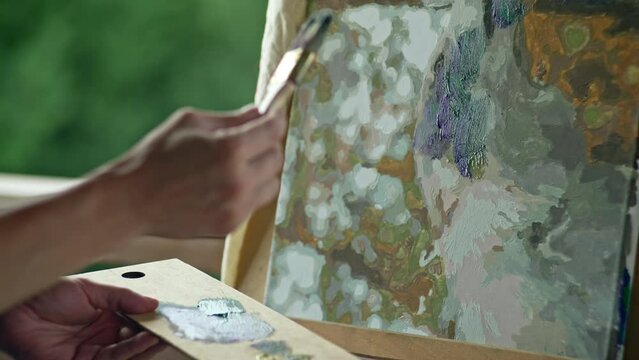 The artist's hands dip the brush in paint and paint a picture. Creativity and art is a hobby of a person. High quality 4k footage