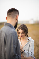 Loving couple of man and woman in the field. A couple in love is walking in the field and enjoying life. Romance and love. Happy and romantic couple. Love between two people.