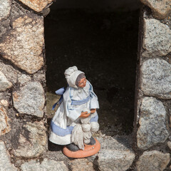 Santon de terre cuite représentant une femme d'autrefois avec son écheveau de laine