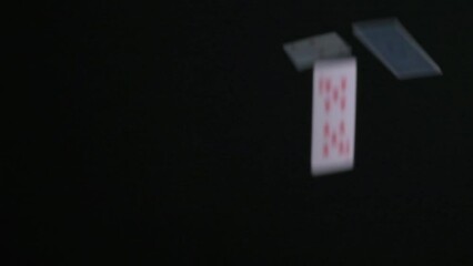 Playing cards are falling in slow motion on a black background. - Powered by Adobe