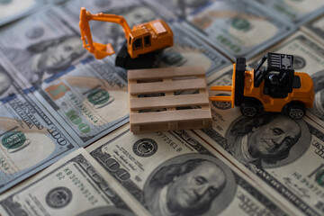 Yellow toy excavator extracts minerals in the form of dollar bills