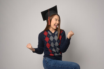 Young smiling woman holding graduation hat, education and university concept.