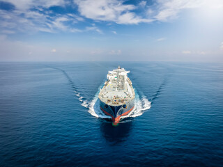 Front view of a large LNG or liquid gas tanker vessel traveling with high speed over blue ocean - 528483493