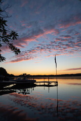 dawn over lake with clouds mirrored and flag