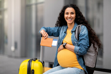 Happy young pregnant woman travelling alone, copy space