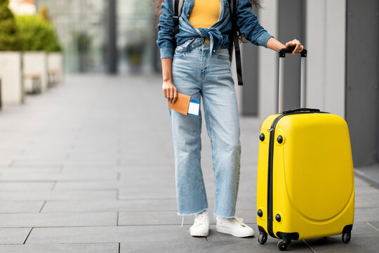 Cropped of woman with suitcase luggage holding passport and tickets
