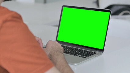 Young Man Using Laptop with Green Chroma Key Screen