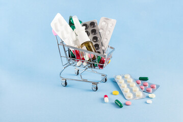 on a blue background a cart with medicines with copy space
