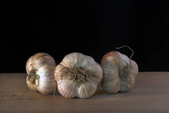 heads of young garlic on a wooden table