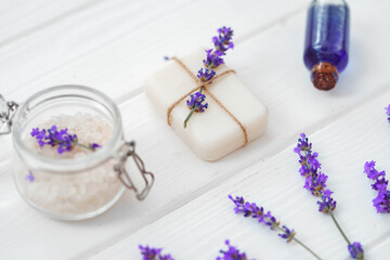 Obraz na płótnie Canvas Lavender soap bars and spa products with lavender flowers on a white wooden table