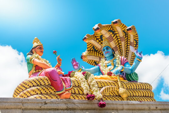 Statue of Lord vishnu and lakshmi Hindu God and goddess in daylight, low angle shot.