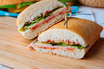 Sandwich with ham and cheese on wooden board