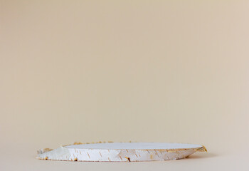 Wooden podium made of birch for cosmetics or perfumes on a marble background.