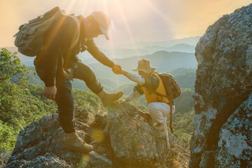 Close-up of helping hand, hiking help each other. Focus on hands. People teamwork climbing or...