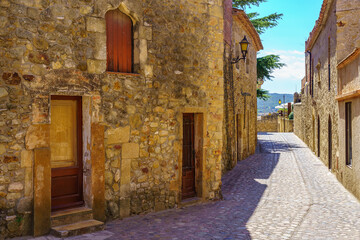 Fototapeta na wymiar Stone houses and narrow alley in the medieval town of Pals, Girona, Spain.