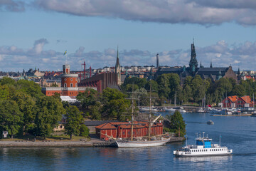Naklejka premium Harbor commuting boat passing the depth Vasa djupet turning to the old town Gamla Stan a sunny autumn day in Stockholm