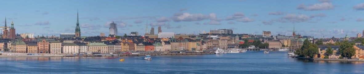 Panorama view over the bay Saltsjön, the old town Gamla Stan, commuting boats, a harbor ferry and...