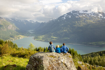 People, adult with kids and pet dog, hiking mount Hoven, enjoying the splendid view over Nordfjord...