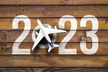 happy new year 2023. year 2023 with toy airplane on vooden desk
