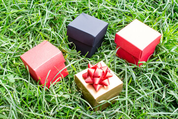 Gift boxes are scattered on the green grass in the park. Holiday, sale.