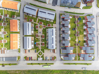 A direct overhead aerial view above a vast residential neighbourhood, seen on a sunny day in the summer.