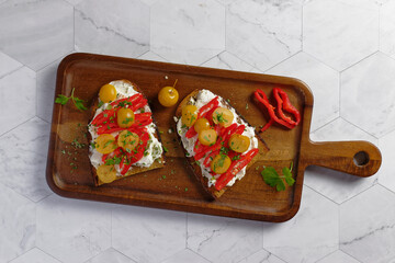 Healthy toast with pointed peppers and siberian crab apple on cream cheese and feta cheese.