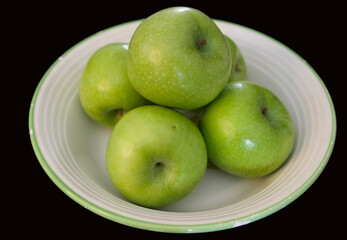 green apples (Granny smith) in a plate on a black background