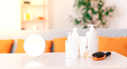 Cosmetic set on a light dressing table. a green bush on the table with cosmetics and a mirror. the concept of home self-care