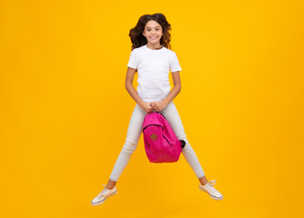 Fototapeta na wymiar Schoolgirl in school uniform with backpack. Teenage girl student on yellow isolated background. Crazy run and jump. Learning and education children.