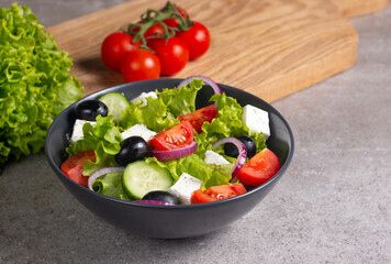 Fresh Greek salad with delicious rucola, spinach, arugula, feta cheese, cucumber, red onion and cherry tomato Healthy and diet food concept.