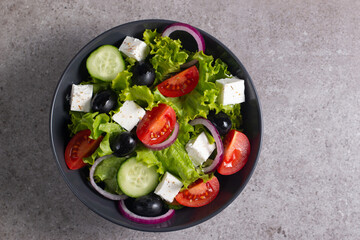 Fresh Greek salad with delicious rucola, spinach, arugula, feta cheese, cucumber, red onion and cherry tomato Healthy and diet food concept.