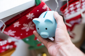 A small ceramic piggy bank with a Christmas tree. In the background of a New Year's gifts. Symbol of the new year 2023. Christmas card.