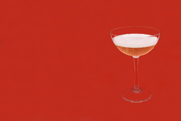 Sparkling wine Martini Asti in a glass on a red background