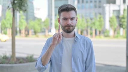Rejecting Young Man Shaking Finger in Denial Outdoor