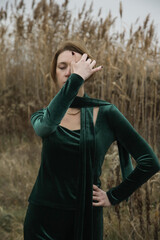 Autumn fashion outdoor portrait of young woman in emerald green set. Comfortable and trendy long sleeved shirt and trousers handmade from plush velvet