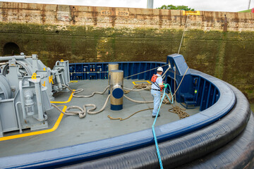Tugboat inside the Miraflores lock on the Panama canal. Crew securing the line